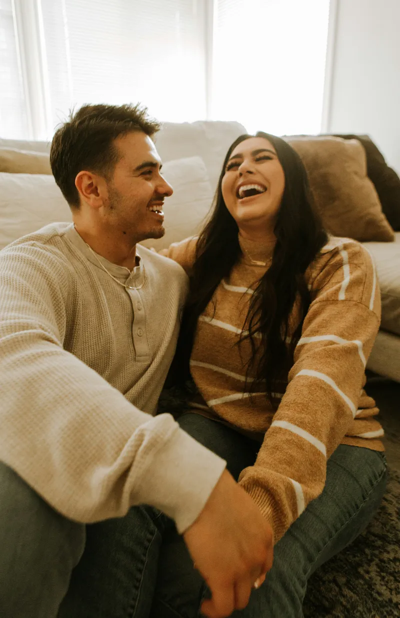 A young man and woman sharing a warm laugh together at home