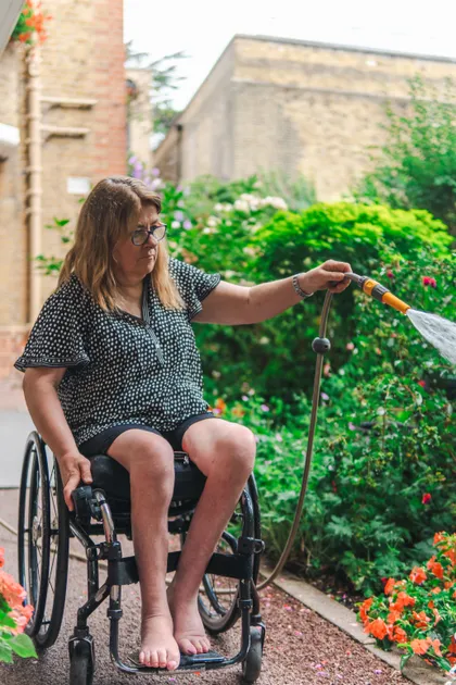 A woman watering the plants in her garden