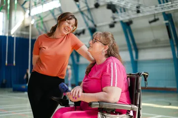 A support worker and participant chatting during a community activity