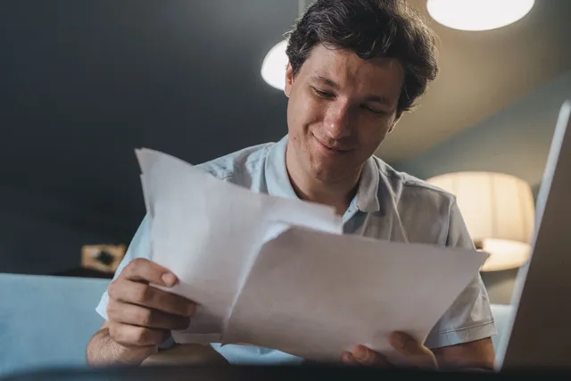 A man reading through his NDIS plan paperwork at home