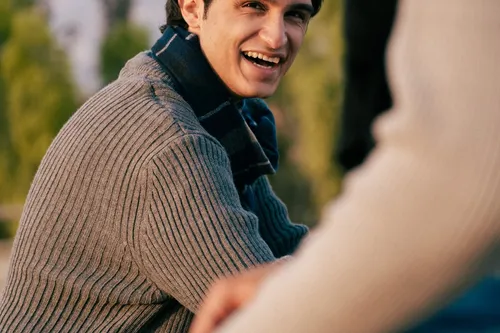 A man smiling warmly outdoors