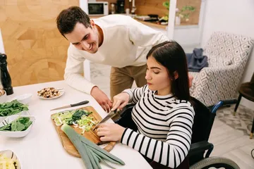 A support worker helping a participant prepare a meal at home