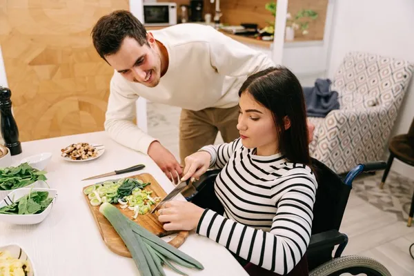 A support worker helping a participant prepare a meal at home