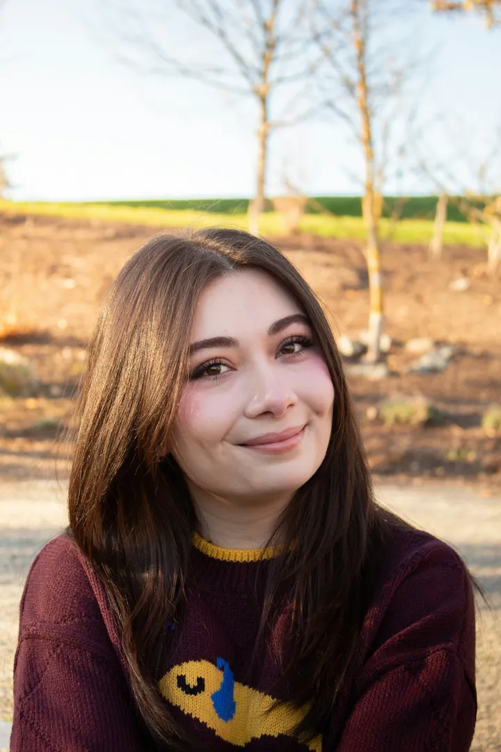 A woman smiling gently outdoors